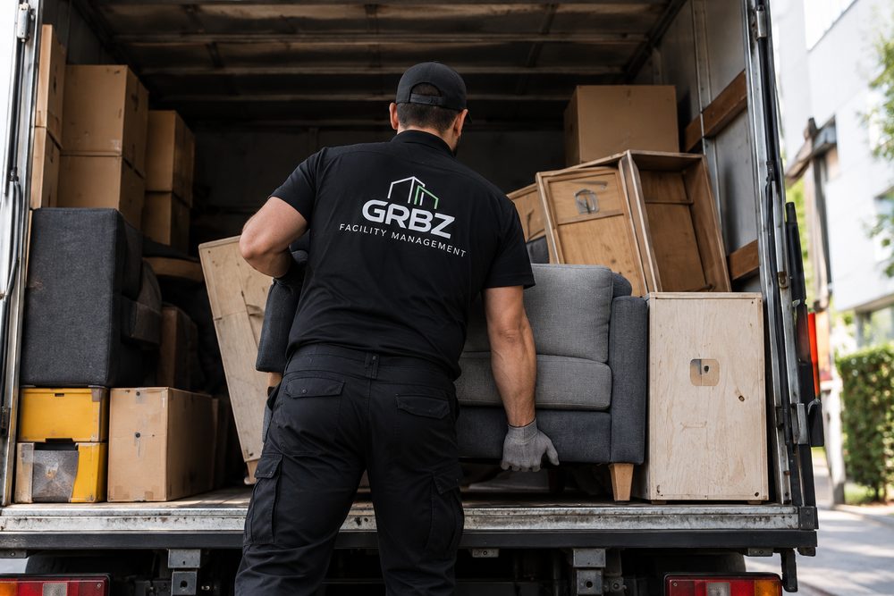 Mitarbeiter räumt Kartons und Möbel aus einem Transporter